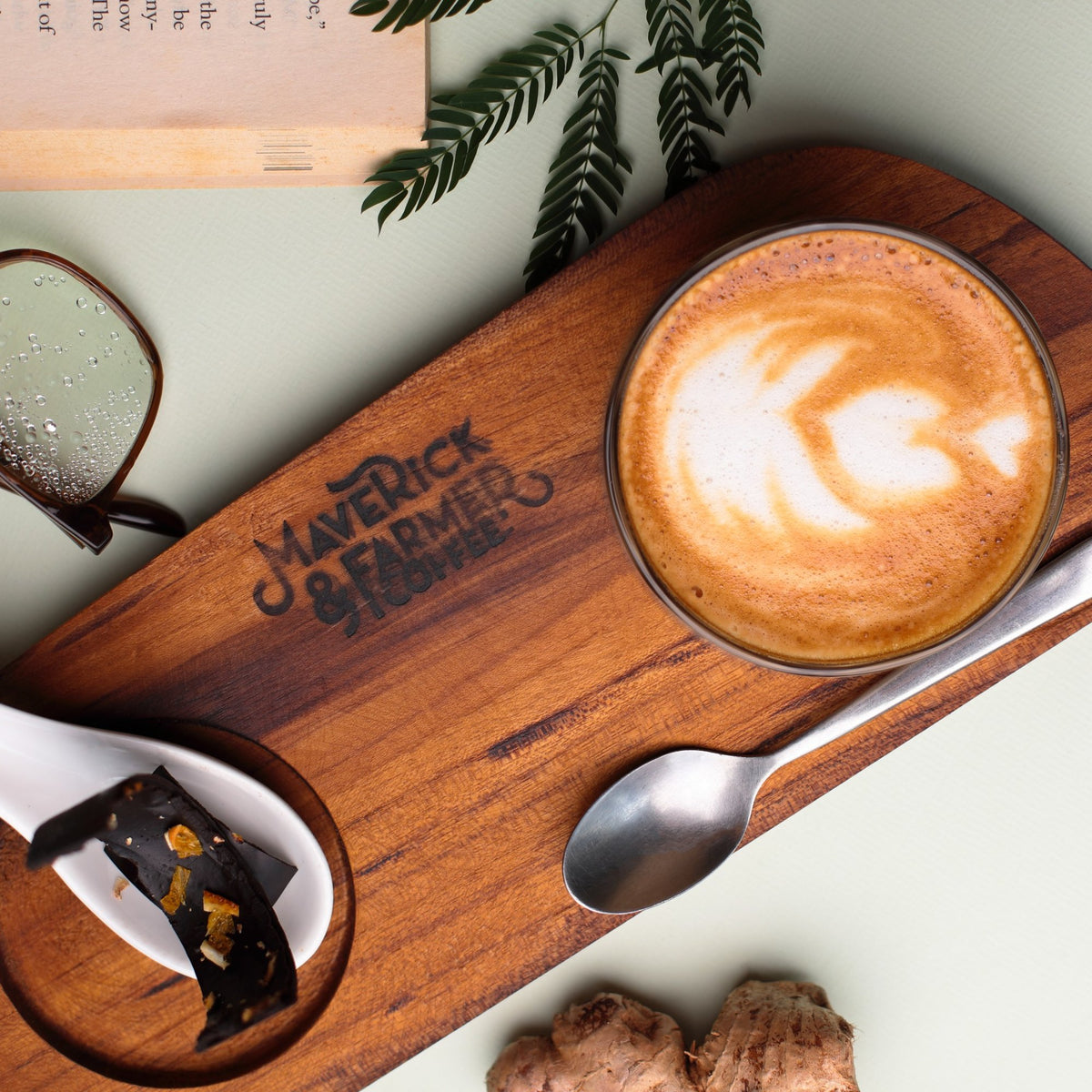 Latte with art served on a Maverick & Farmer wooden tray.